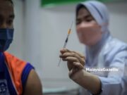 Healthcare worker showing a syringe containing Pfizer-BioNTech Covid-19 vaccine to a student from SMK Putrajaya during the National Covid-19 Immunisation Programme (PICK) for Adolescents. PIX: HAZROL ZAINAL / MalaysiaGazette / 20 SEPTEMBER 2021