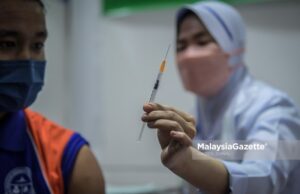Healthcare worker showing a syringe containing Pfizer-BioNTech Covid-19 vaccine to a student from SMK Putrajaya during the National Covid-19 Immunisation Programme (PICK) for Adolescents. PIX: HAZROL ZAINAL / MalaysiaGazette / 20 SEPTEMBER 2021
