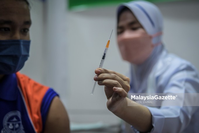 Healthcare worker showing a syringe containing Pfizer-BioNTech Covid-19 vaccine to a student from SMK Putrajaya during the National Covid-19 Immunisation Programme (PICK) for Adolescents. PIX: HAZROL ZAINAL / MalaysiaGazette / 20 SEPTEMBER 2021