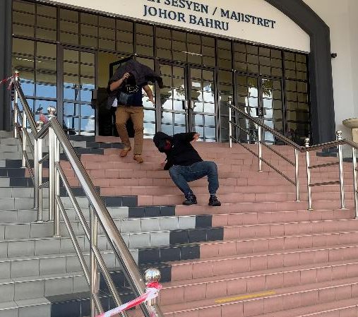 One of the two MACC officers charged with corruption fell down at the stairs while trying to run away from being photographed by the media at the Johor Bahru Sessions court.