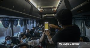 Bus driver at Terminal Bersepadu Selatan (TBS) inspecting the vaccination certificate of the passengers before they are allowed to return to their hometown during the first day of lifting the interstate travel ban. Prime Minister, Datuk Seri Ismail Sabri Yaakob announced the reopening of state borders as the country has reached 90 percent of adult vaccination rate yesterday. PIX: AFFAN FAUZI / MalaysiaGazette / 11 OCTOBER 2021