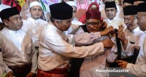The President of UMNO, Datuk Seri Dr. Ahmad Zahid Hamidi puts the Penyatuan Ummah jacket on the President of PAS, Datuk Seri Abdul Hadi Awang during the Launch of Selangor Muafakat Nasional. PIX: AFFAN FAUZI / MalaysiaGazette / 23 NOVEMBER 2019 PPBM Bersatu GE15