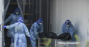 The staff managing Covid-19 bodies for burial at the One-Stop Corpse Management Centre (PUSUM), Kuala Lumpur. PIX: HAZROL ZAINAL / MalaysiaGazette / 26 JULY 2021 Covid-19 deaths