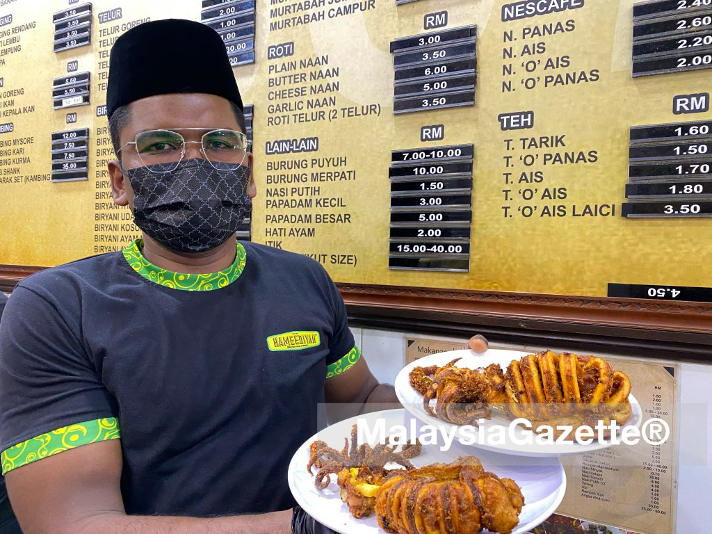 Muhammad Riyaaz showing the fried squid sold at his restaurant.