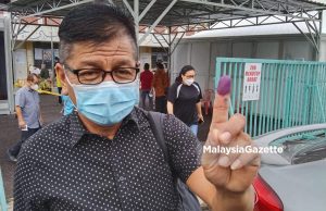 Norhizam Hassan Baktee showing his inked finger after casting his vote at Sekolah Rendah Agama JAIM, Taman Datuk Thamby Chik Karim today.