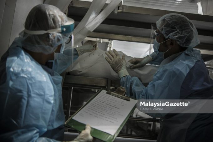 The healthcare workers from the Forensics Unit of Sultanah Aminah Hospital in Johor managing the corpses at a special refrigerated container following the rise of Covid-19 death in the country. FILE PIX: HAZROL ZAINAL / MalaysiaGazette / 06 JUNE 2021