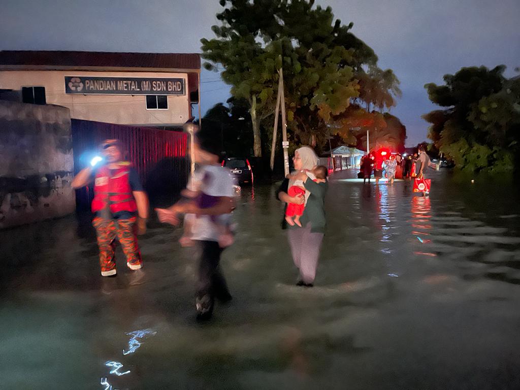 The firefighters mobilising the rescued residents in Taman Sri Muda, Shah Alam.
