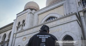 appeal conviction Najib A supporter of Datuk Seri Najib Razak wearing a T-Shirt with ‘Ku Mohon PadaMu Selamatkan DSNR Kami’ inscribed on it as a sign of support to the former Prime Minister on his appeal verdict day at the Palace of Justice, Putrajaya. PIX: HAZROL ZAINAL / MalaysiaGazette / 08 DISEMBER 2021. SRC International Sdn Bhd appeal verdict