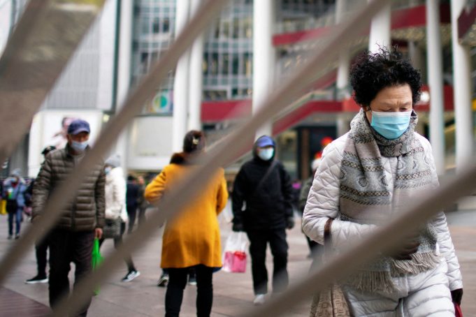 People wearing face masks following the COVID-19 outbreak walk on a street in Shanghai