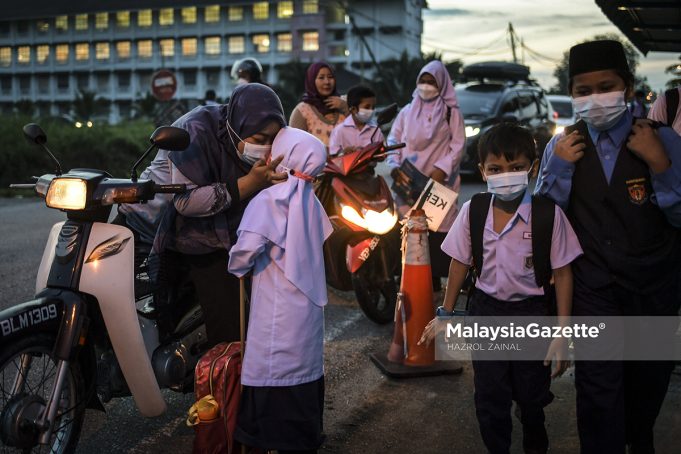 Parents dropping off their children to school at Sekolah Kebangsaan Bukit Changgang, Banting, Selangor during the first day of the third 2021/2022 school term. PIX: HAZROL ZAINAL / MalaysiaGazette / 10 JANUARY 2022