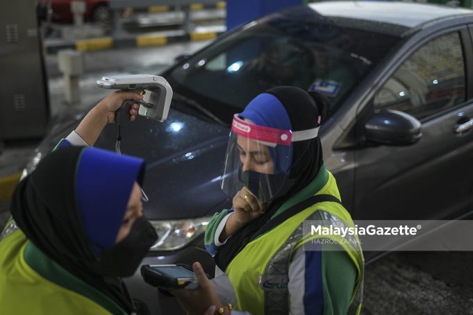 An employee from PLUS scans a vehicle with Radio Frequency Identification (RFID) tag issues using a mobile device at the Sungai Besi Toll Plaza in Kuala Lumpur. PIX: HAZROL ZAINAL / MalaysiaGazette / 17 JANUARY 2022.