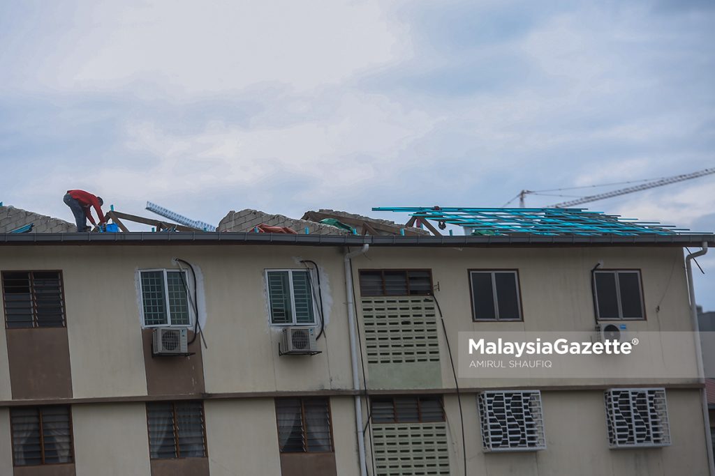  Construction workers repairing the roof of Taman Melati Flat in Setapak, Kuala Lumpur that was destroyed in a rainstorm. PIX: AMIRUL SHAUFIQ / MalaysiaGazette / 7 FEBRUARY 2022