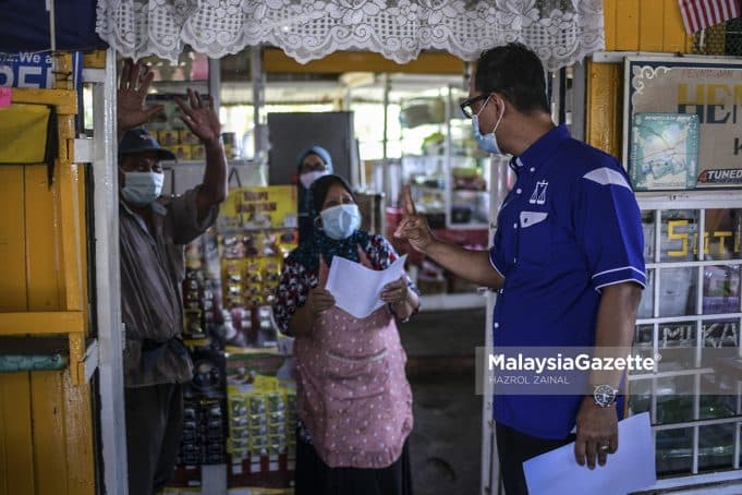 Calon Barisan Nasional (BN) N.14 Bukit Naning, Datuk Mohd Fuad Tukirin (kanan) beramah mesra dengan pengundi ketika sesi walkabout sempena kempen Pilihan Raya Negeri (PRN) Johor di Warung Hentian Mesra Selalu, Muar, Johor. Foto HAZROL ZAINAL, 28 FEBRUARI 2022.