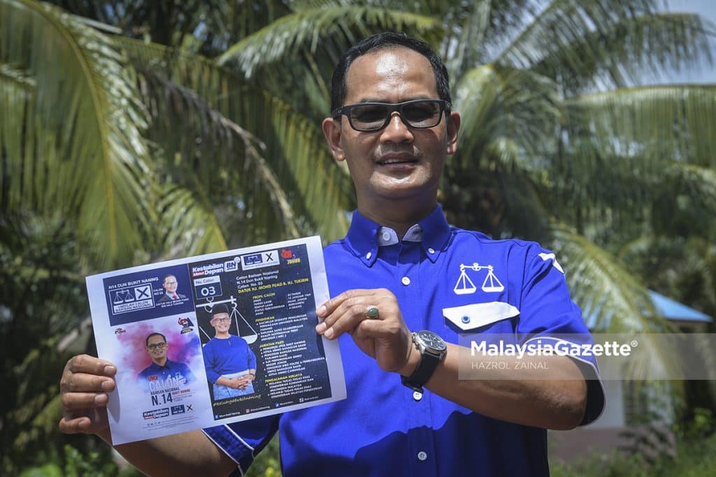 Calon Barisan Nasional (BN) N.14 Bukit Naning, Datuk Mohd Fuad Tukirin menunjukkan risalah kempen sempena kempen Pilihan Raya Negeri (PRN) Johor di Warung Hentian Mesra Selalu, Muar, Johor. Foto HAZROL ZAINAL, 28 FEBRUARI 2022.