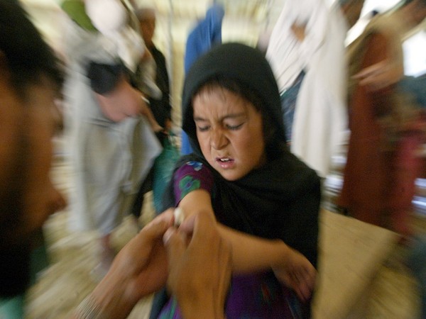 A YOUNG AFGHAN REFUGEE GIRL IS VACCINATED AGAINST MEASLES IN KABUL.