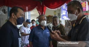 Pengerusi PN, Tan Sri Muhyiddin Yassin (tengah) bersama calon Perikatan Nasional N.09 Gambir, Mohd Solihan Badri (kiri) beramah mesra dengan masyarakat cina bagi meraih undi sempena kempen Pilihan Raya Negeri (PRN) Johor di Bukit Gambar, Tangkak, Johor. Foto HAZROL ZAINAL, 29 FEBRUARI 2022.