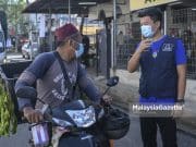 Calon Barisan Nasional (BN) N.10 Tangkak, Ong Chee Siang (kanan) menyantuni sebahagian penduduk setempat bagi meraih undi ketika sesi walkabout sempena kempen Pilihan Raya Negeri (PRN) Johor di Pasar Awam Tangkak, Johor. Foto HAZROL ZAINAL, 03 MAC 2022.