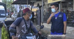 Calon Barisan Nasional (BN) N.10 Tangkak, Ong Chee Siang (kanan) menyantuni sebahagian penduduk setempat bagi meraih undi ketika sesi walkabout sempena kempen Pilihan Raya Negeri (PRN) Johor di Pasar Awam Tangkak, Johor. Foto HAZROL ZAINAL, 03 MAC 2022.