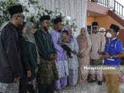 Calon Barisan Nasional (BN) N.09 Gambir, Sahrihan Jani (kanan) bergambar dengan bapa pengantin, Jazali Othman (empat kiri) serta tiga pasangan pengantin ketika berkempen di salah satu majlis perkahwin sempena Pilihan Raya Negeri (PRN) Johor di Kampung Sawah Ring, Bukit Gambir, Johor. Foto HAZROL ZAINAL, 05 MAC 2022. Foto HAZROL ZAINAL, 05 MAC 2022.