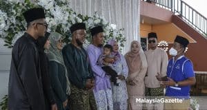 Calon Barisan Nasional (BN) N.09 Gambir, Sahrihan Jani (kanan) bergambar dengan bapa pengantin, Jazali Othman (empat kiri) serta tiga pasangan pengantin ketika berkempen di salah satu majlis perkahwin sempena Pilihan Raya Negeri (PRN) Johor di Kampung Sawah Ring, Bukit Gambir, Johor. Foto HAZROL ZAINAL, 05 MAC 2022. Foto HAZROL ZAINAL, 05 MAC 2022.