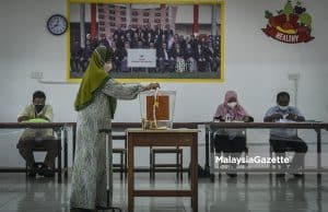 Pengundi membuang undi di pusat mengundi DUN Maharani pada hari pengundian sempena Pilihan Raya Negeri (PRN) Johor di SMK Seri Muar, Johor. Foto HAZROL ZAINAL, 12 MAC 2022.