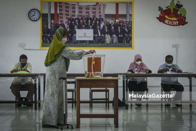 Pengundi membuang undi di pusat mengundi DUN Maharani pada hari pengundian sempena Pilihan Raya Negeri (PRN) Johor di SMK Seri Muar, Johor. Foto HAZROL ZAINAL, 12 MAC 2022.