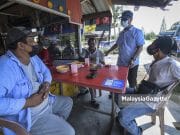 ADUN Bukit Naning baharu, Datuk Mohd Fuad Tukirin (dua kanan) menyantuni pengundi sebagai tanda terima kasih selepas memenangi kerusi Pilihan Raya Negeri (PRN) Johor N.14 Bukit Naning di Warung Hentian Mesra Selalu, Muar, Johor. Foto HAZROL ZAINAL, 13 MAC 2022.