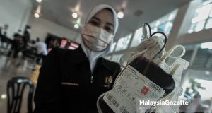 A nurse showing the blood bag during the Blood Donation Campaign launch in conjunction with the 215th Police Day Celebration at the Kuala Lumpur Police Contingent Headquarters. PIX: MUHD NA'IM / MalaysiaGazette / 31 MARCH 2022