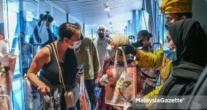 The Minister of Tourism, Art and Culture, Datuk Seri Nancy Shukri greets the passengers as they disembark at the Kuala Lumpur International Airport (KLIA). The Etihad Airway EY0418 flight landed safely with 283 passengers on board as the Malaysia reopens its national borders. PIX: MOHD ADZLAN / MalaysiaGazette /1 APRIL 2022