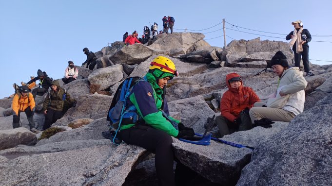 MAIN PIX 1 - Kartina Abdul Ghani sedang menyiapkan aplikasi mudah alih di puncak Gunung Kinabalu pada Ahad. - Gambar Sekretariat Ekspedisi AMB