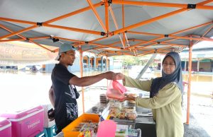 Peniaga tetap mencari rezeki walaupun air pasang besar