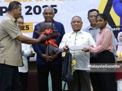 Menteri Besar Perak, Datuk Seri Saarani Mohamad menyampaikan komputer riba kepada pelajar di bawah Program Anak Angkat Cikgu Saarani, K Tamilvili, 18, yang memperoleh keputusan cemerlang dalam Sijil Pelajaran Malaysia (SPM) 2024 pada Majlis Pelancaran Program Mahasiswa Perak Sejahtera (MPS) 2030 di Universiti Teknologi MARA (UiTM), Kampus Seri Iskandar. Foto ABDULLAH YUSOF, 05 MEI 2025.