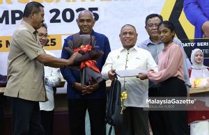 Menteri Besar Perak, Datuk Seri Saarani Mohamad menyampaikan komputer riba kepada pelajar di bawah Program Anak Angkat Cikgu Saarani, K Tamilvili, 18, yang memperoleh keputusan cemerlang dalam Sijil Pelajaran Malaysia (SPM) 2024 pada Majlis Pelancaran Program Mahasiswa Perak Sejahtera (MPS) 2030 di Universiti Teknologi MARA (UiTM), Kampus Seri Iskandar. Foto ABDULLAH YUSOF, 05 MEI 2025.
