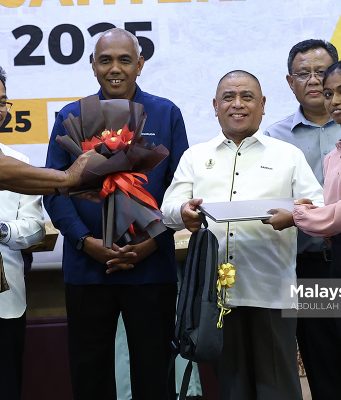 Menteri Besar Perak, Datuk Seri Saarani Mohamad menyampaikan komputer riba kepada pelajar di bawah Program Anak Angkat Cikgu Saarani, K Tamilvili, 18, yang memperoleh keputusan cemerlang dalam Sijil Pelajaran Malaysia (SPM) 2024 pada Majlis Pelancaran Program Mahasiswa Perak Sejahtera (MPS) 2030 di Universiti Teknologi MARA (UiTM), Kampus Seri Iskandar. Foto ABDULLAH YUSOF, 05 MEI 2025.