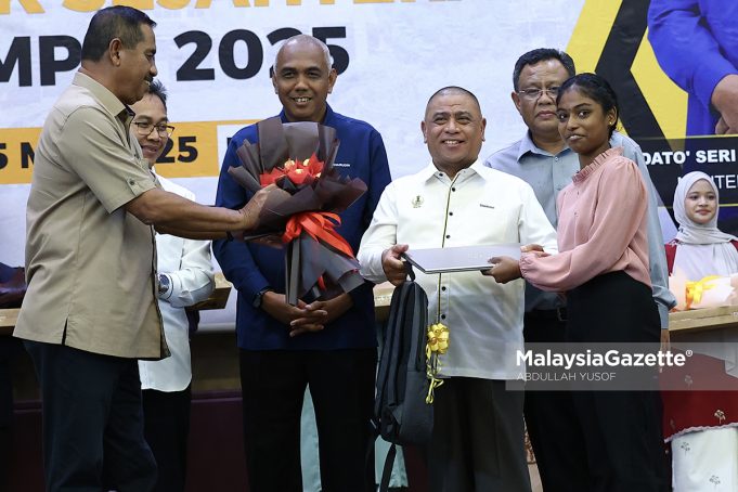 Menteri Besar Perak, Datuk Seri Saarani Mohamad menyampaikan komputer riba kepada pelajar di bawah Program Anak Angkat Cikgu Saarani, K Tamilvili, 18, yang memperoleh keputusan cemerlang dalam Sijil Pelajaran Malaysia (SPM) 2024 pada Majlis Pelancaran Program Mahasiswa Perak Sejahtera (MPS) 2030 di Universiti Teknologi MARA (UiTM), Kampus Seri Iskandar. Foto ABDULLAH YUSOF, 05 MEI 2025.