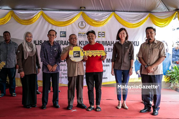 MAJLIS PENYERAHAN KUNCI RUMAH PERAKKU Menteri Besar Perak, Datuk Seri Saarani Mohamad (empat, kiri) menyerahkan replika kunci rumah kepada Asri Awang Ahmad, 45, pada Majlis Penyerahan Kunci Rumah Perakku di Taman Perakku Batu 14, Lekir, pada Khamis. Foto ANIQ NABILAFIQ ANUAR, 24 JULAI 2025. rumah mampu milik Perak Sejahtera 2030