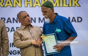 Menteri Besar Perak, Datuk Seri Saarani Mohamad menyerahkan geran hakmilik kepada penerima pada Majlis Penyerahan Geran Hakmilik Bagi RPT Sungai Tiram, Mukim Lekir dan RPT Sungai Batu, Mukim Pengkalan Baharu di Dewan Pegawai Daerah, Pejabat Daerah dan Tanah Manjung, pada Isnin. Foto ANIQ NABILAFIQ ANUAR, 12 JANUARI 2026.