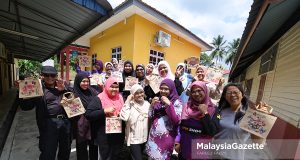 Tenaga Pengajar, Nuraini A Jalil (tengah) bergambar kenangan dengan para peserta sambil menunjukkan hasil karya seni beg jut di Pusat Komuniti Desa Gagu, Kuala Klawang, Jelebu. Foto FAREEZ FADZIL, 24 JULAI 2026.
