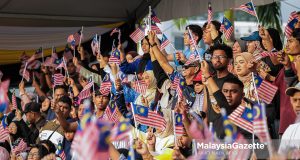 Orang ramai mengibarkan Jalur Gemilang pada Sambutan Hari Kebangsaan Ke-69 Peringkat Negeri Perak bertemakan “Malaysia MADANI: Kesejahteraan Dinikmati” di pekarangan Dewan Bandaran Ipoh, pada Isnin. Foto ANIQ NABILAFIQ ANUAR, 30 OGOS 2026.
