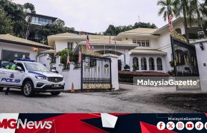 Kenderaan polis di hadapan sebuah kediaman di Langgak Duta
